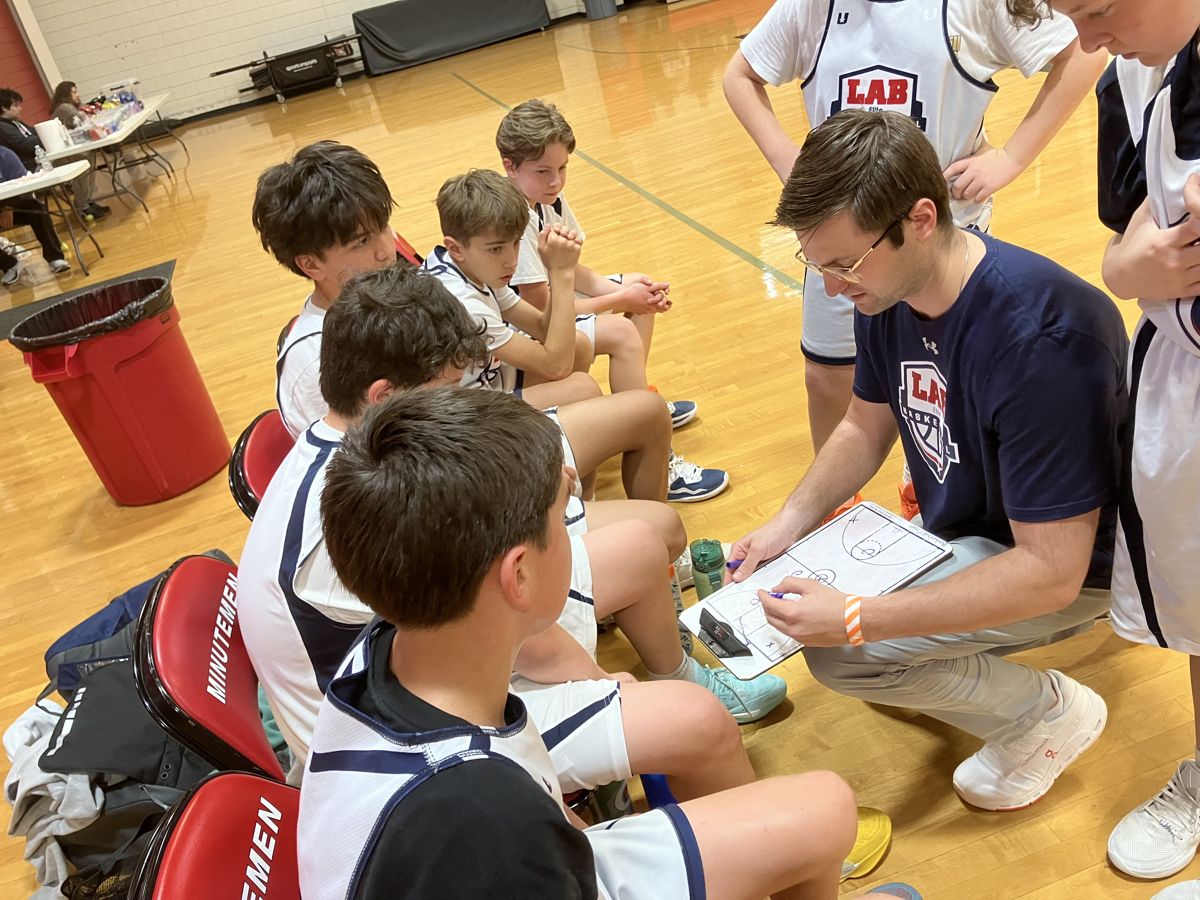 Coach reviewing a game plan with LAB Elite players
